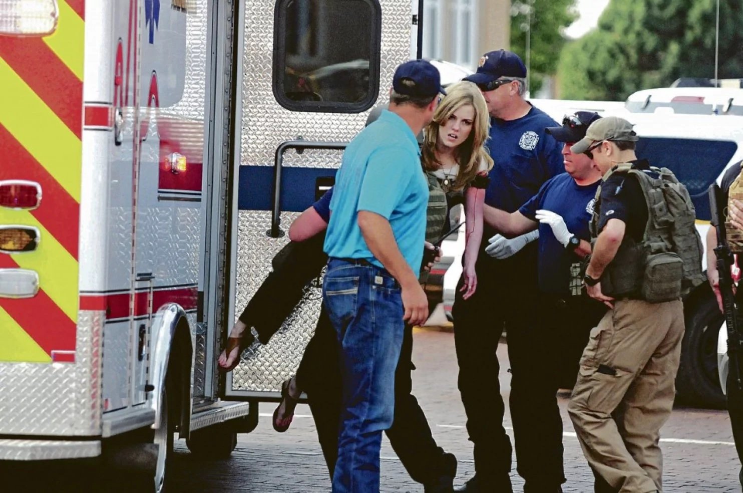 An injured woman is carried to an ambulance in Clovis