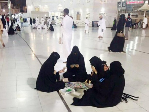 Burqa-clad women playing a board game in the premises of Mecca