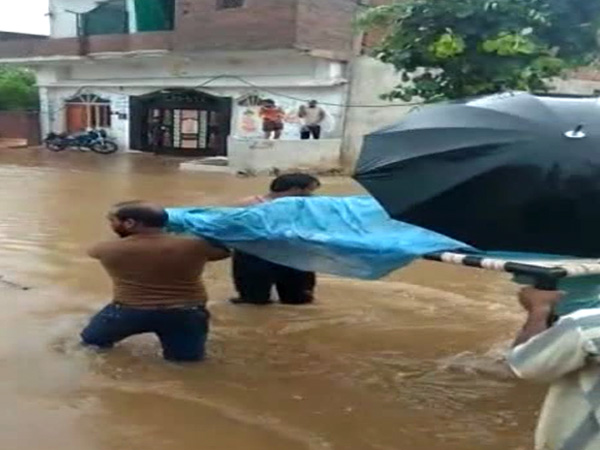 Pregnant woman carried on cot through flooded streets