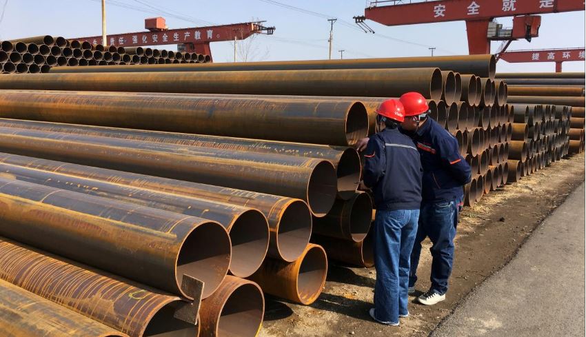 Workers inspect steel pipes at a steel mill of Hebei Huayang Steel Pipe Co Ltd in Cangzhou, Hebei province, China