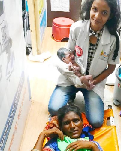 A one-rupee clinic staff holding a baby of the woman at Thane railway station