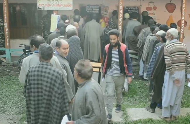 Voters line up outside polling booths in Anantnag