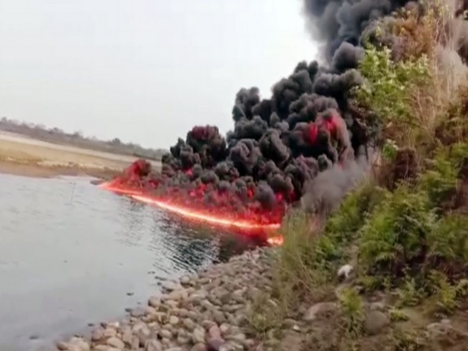 Heavy smoke and flames come out after a blast in oil pipeline, near Burhi Dihing river in Dibrugarh