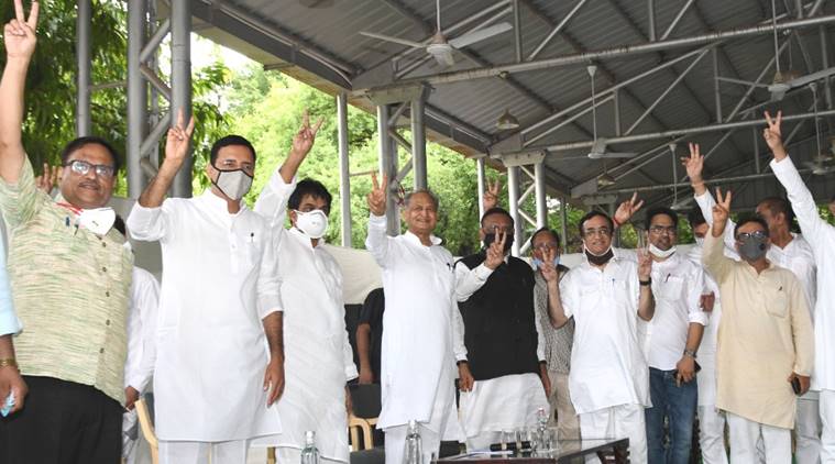 Rajasthan Chief Minister Ashok Gehlot flashes the victory sign along with Congress leaders Randeep Singh Surjewala, Ajay Maken and other MLAs at his residence on Monday.