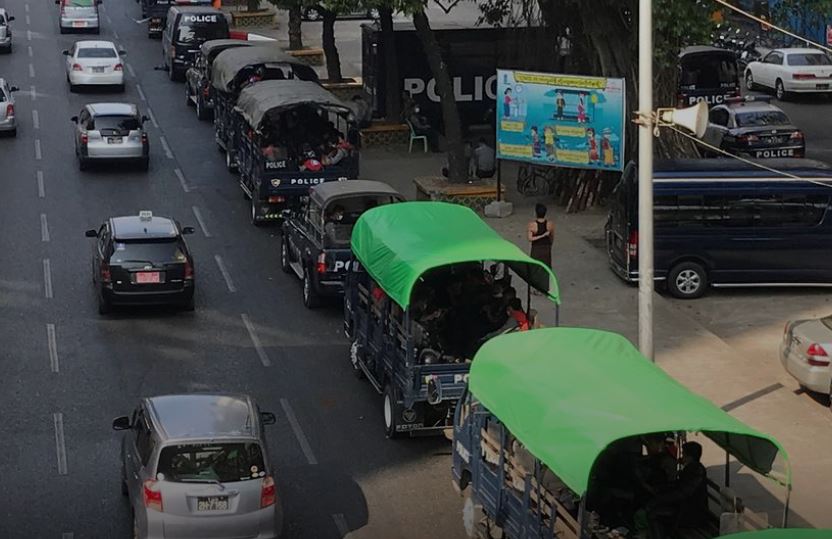 Myanmar police vehicles drive near the City Hall in Yangon