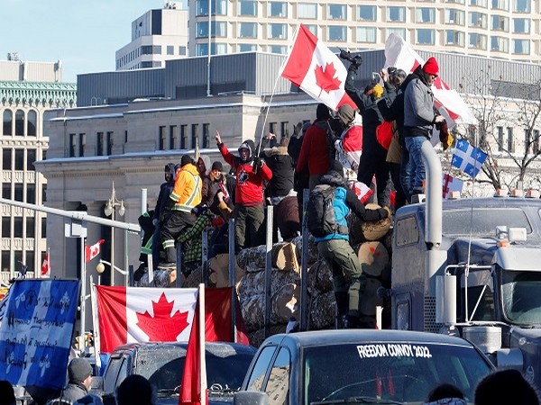 Protestors stand on a trailer carrying logs as truckers and supporters take part in a convoy to protest COVID-19 vaccine mandates in Ottawa, Ontario, Canada, January 29
