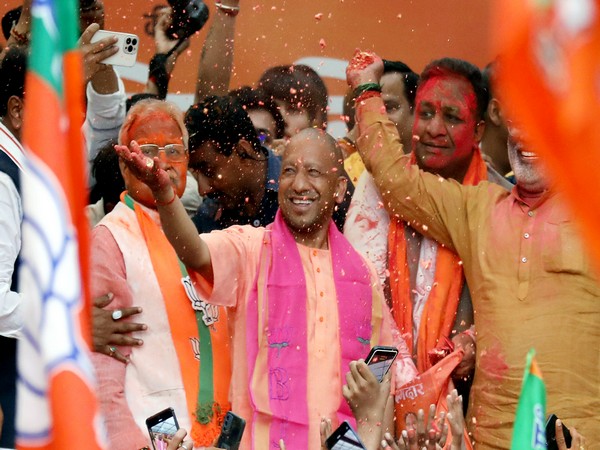 Uttar Pradesh's acting Chief Minister Yogi Adityanath celebrates after BJP wins in UP polls