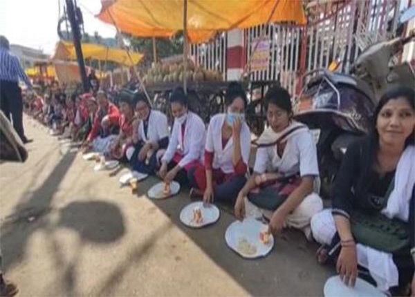 Contract health workers eating straw