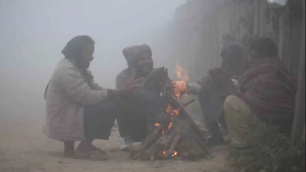 People huddled around bonfire in Delhi.