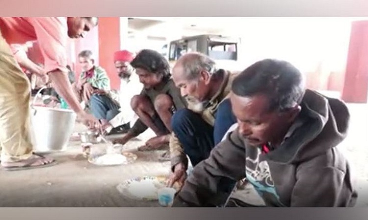 People eating food cooked by Dipu Gogoi and his friends