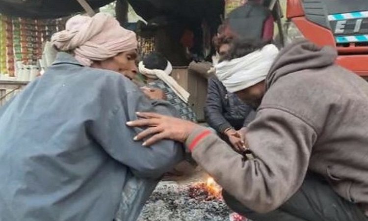 People huddled around a bonfire to ward off the cold